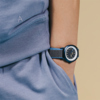Armbanduhr TIKK Moon an einem Kinderhandgelenk, getragen mit einem blauen Klettband.