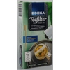 Teefiltertüten in Verpackung mit Teebecher und Teelöffel auf Unterteller.
