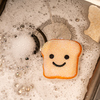 Schaumiger Spülbecken mit einem Smiley-Toast-Reinigungsschwamm auf einer spülenden Oberfläche.