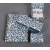 Elegante Aufbewahrungsbox mit floralem Muster, umgeben von Notizbuch und weiteren Boxen.