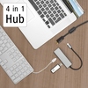 USB-C-Hub mit vier Anschlüssen, verbunden mit einem Laptop und weiteren Geräten auf einem Tisch.