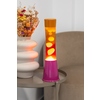 Lavalampe in Pink und Orange auf einem Tisch neben einer dekorativen Blumenvase.