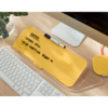 Gelbes Memoboard mit Notizen, platziert auf einem Schreibtisch neben einer Tastatur und Zubehör.