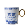 Tasse mit humorvollen Illustrationen von tierischen Figuren und goldenem Henkel.