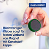 Grüner Magnet mit Kunststoffkappe wird von einer Hand an einer Tafel platziert.
