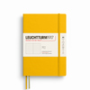 Gelbes Softcover-Notizbuch im A5-Format mit punktkariertem Inhalt und Gummibandverschluss.
