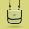Brustbeutel in Lime mit schwarzem Rand und Karabinern, hängend auf einem gelben Hintergrund.