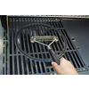 Grillbürste in Verwendung auf einem Grillrost, handgehalten mit Edelstahlborsten.