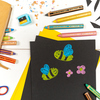 Buntstifte in verschiedenen Farben liegen auf schwarzem Papier mit bunten Zeichnungen.