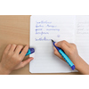 Füllfederhalter Scribolino in blau in der Hand eines Kindes beim Schreiben in ein Notizbuch.