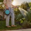 Tragbare GARDENA Schlauchaufroller Move in der Anwendung beim Bewässern von Pflanzen im Garten.
