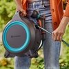 Tragbare GARDENA Schlauchaufroller MoveMatic in Hand mit Schlauch zum Bewässern im Freien.
