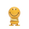 Gelbe Dekorationsfigur in Smiley-Form mit lächelndem Gesicht und spiralförmigem Unterteil.