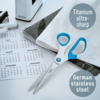 Blau-gelbe Universalschere mit titaniumbeschichteten Klingen auf einem Schreibtisch mit Kalender.