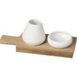 Servierset aus Keramik mit einer Kanne und einer Schale auf einem Holzbrett platziert.