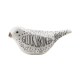 Weiße Dekorationsfigur in Vogelform mit dem Schriftzug "GLÜCKSBRINGER" in Schwarz.