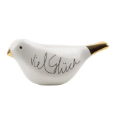 Dekorationsfigur in Form eines Vogels mit Aufschrift "Viel Glück" und goldfarbenem Schnabel.
