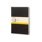 Schwarzes Moleskine Notizheft Cahier XL mit kariertem Papier und gelbem Etikett.