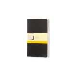 Schwarzes Moleskine Notizheft Cahier L mit kariertem Papier und einem gelben Etikett.