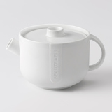 Weiße Teekanne aus Porzellan mit schlichtem Design und seitlichem Ausguss.