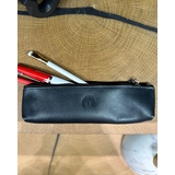 Schwarzes Schlampermäppchen aus Rindsleder mit geprägtem Logo und gefüllten Stiften.