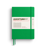 Kariertes, grünes Hardcover-Notizbuch im DIN A5-Format mit Gummiband und Etikett.
