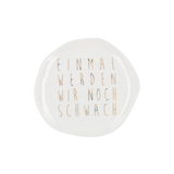 Kleiner, organisch geformter Porzellanteller mit goldener Schrift "Einmal werden wir noch schwach".
