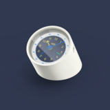 Wecker in rundem Design mit dunklem Ziffernblatt und gelb-blauem Uhrzeiger auf weißem Gehäuse.