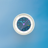 Runder Wecker mit bunten Zeigern und schlichtem Ziffernblatt auf blauem Hintergrund.