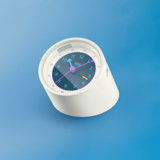 Bunter Wecker mit Ziffernblatt, Zeigern und integriertem Nachtlicht auf blauem Hintergrund.