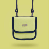 Brustbeutel in Lime mit schwarzem Rand und Karabinern, hängend auf einem gelben Hintergrund.