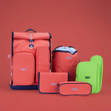 Schulrucksack und Zubehör in bunten Farben auf rotem Hintergrund.