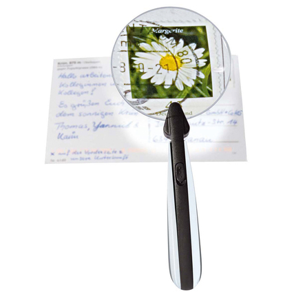 Runde Lupe mit LED-Licht auf einer Karte mit handschriftlichem Text und Blumenmotiv.