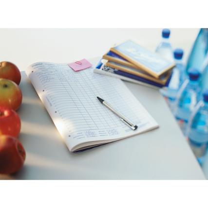 Inventurbuch auf einem Tisch mit Stift, Äpfeln und Wasserflaschen im Hintergrund.