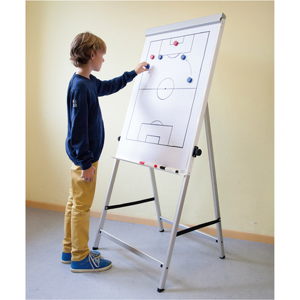 Flipchart mit Taktikfeld und magnetischen Spielsteinen, benutz von einem stehenden Kind.