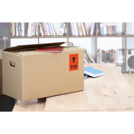 Braune Kartonbox mit rotem Universaletikett "TOP" auf der Vorderseite, auf einem Tisch platziert.