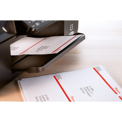 Drei gedruckte Adressetiketten liegen auf einem Drucker mit leicht geöffnetem Auswurf.