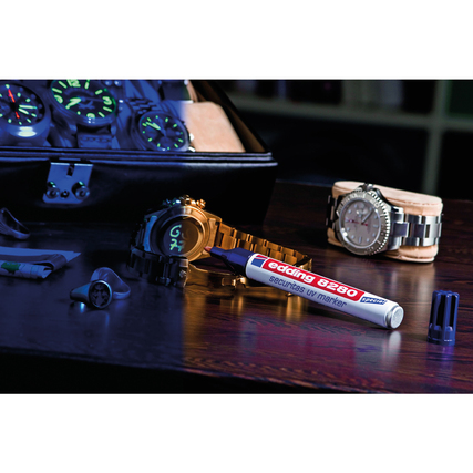 UV Marker auf Tisch mit Uhren und weiteren Dekorationsobjekten im Hintergrund.