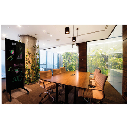 Schwarzes Glasboard als kreatives Element in einem modern eingerichteten Meetingraum.