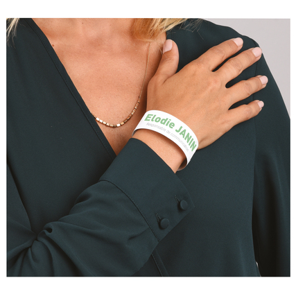 Weißes Eventband mit Aufdruck an einem Handgelenk, getragen von einer Person.