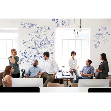 Personen in einem modernen Büro, umgeben von mit Ideen und Grafiken beschriebenen Wänden.
