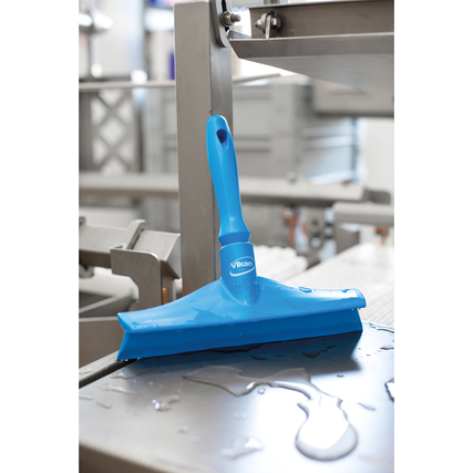 Blauer Duschabzieher mit flexibler Lippe auf einer glatten Oberfläche mit Wasseransammlungen.