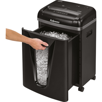 Aktenvernichter mit herausgezogenem Auffangbehälter und Hand, die Papierschnipsel zeigt.