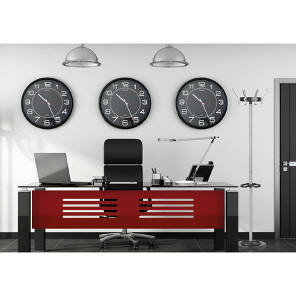 Garderobenständer Cypres in einem modernen Büro mit Uhren und einem Schreibtisch im Hintergrund.
