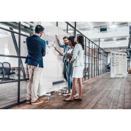 Mobiles, doppelseitiges Whiteboard in einem modernen Büroraum, genutzt von drei Personen.