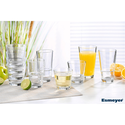 Longdrinkglas mit verschiedenen Getränken, daneben frische Früchte auf einem Tisch.