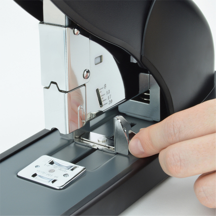 Hand, die den Hebel eines schwarzen Heftgeräts aus recyceltem Plastik drückt.