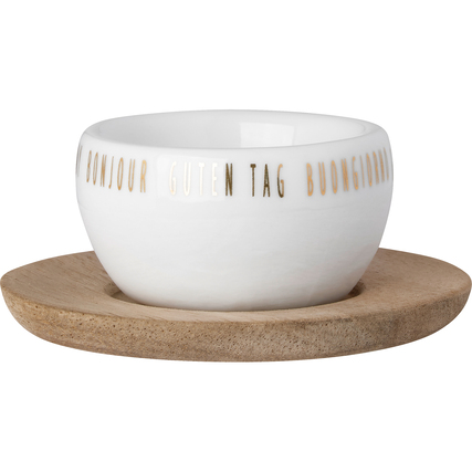 Eierbecher aus weißem Porzellan mit Holzuntersetzer und verschiedensprachigem Schriftzug.