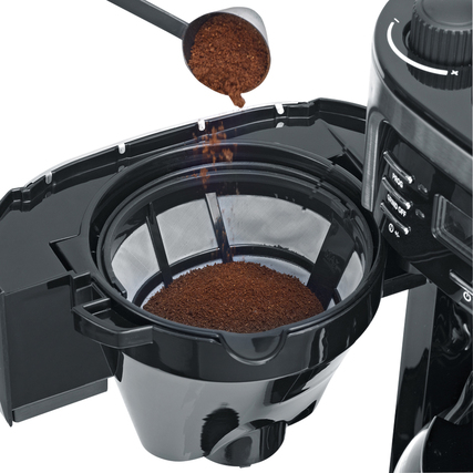 Kaffeepulver wird in einen herausnehmbaren Filter einer Kaffeemaschine eingegeben.