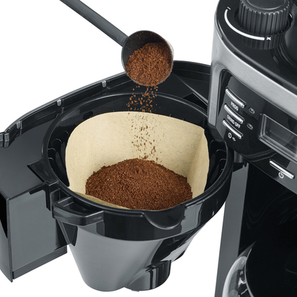 Kaffeepulver wird in einen Schwenkfilter mit Tropfverschluss einer Kaffeemaschine eingefüllt.